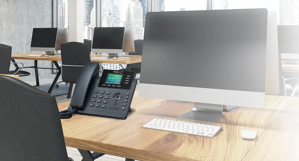 Điện thoại bàn IP đặt trên bàn làm việc trong văn phòng hiện đại.