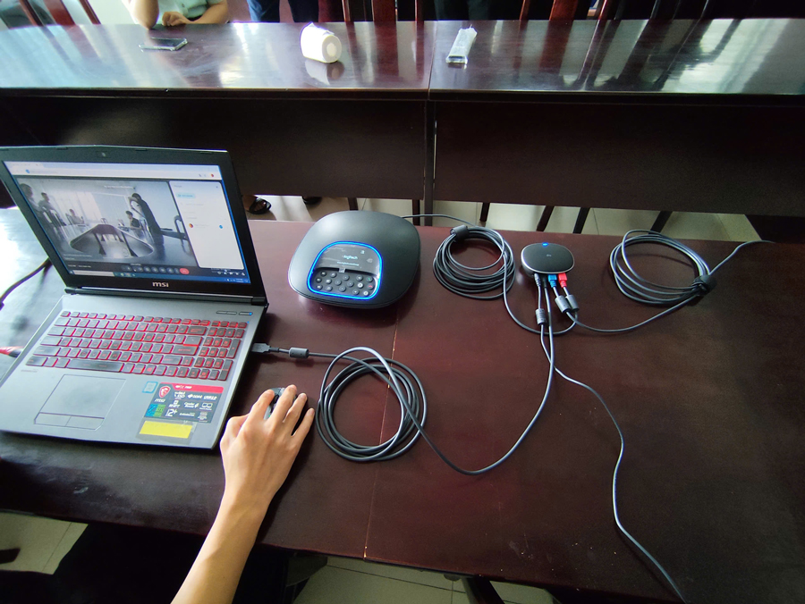 Nhân viên kỹ thuật đang kết nối và cài đặt thiết bị hội nghị Logitech Group